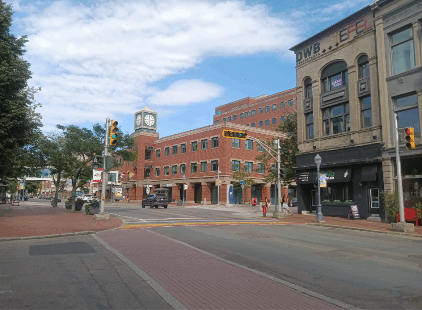 An intersection in downtown Moncton with brick and rainbow crosswalks.