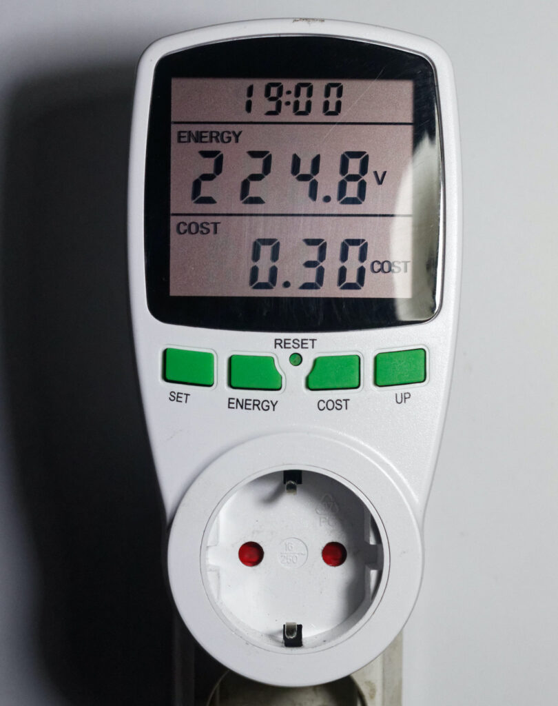 An energy meter displaying the energy used in volts and cost.