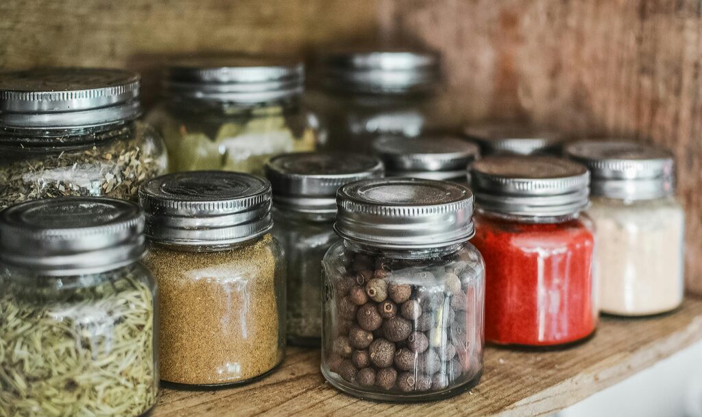 Rows of small glass jars contain colourful herbs and spices.