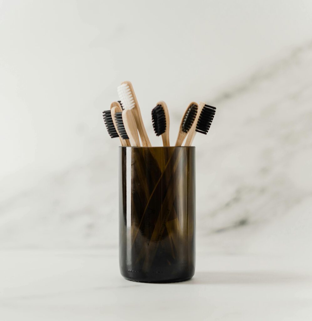 A dark glass full of bamboo toothbrushes.