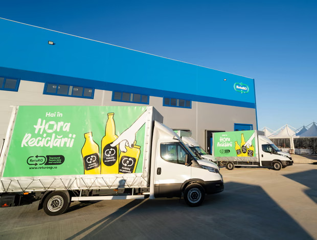 Trucks from Romania's bottle deposit system parked outside a warehouse.